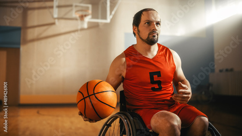 Portrait of Handsome Wheelchair Basketball Player Wearing Red Shirt Dribbling Ball, Ready to Shoot it Perfectly. Determined Person with Disability who is Gonna Win and be Champion © Gorodenkoff