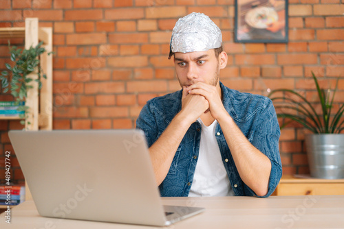 Obraz na plátne Front view of shocked male conspiracy theorist wearing aluminum foil protect bra