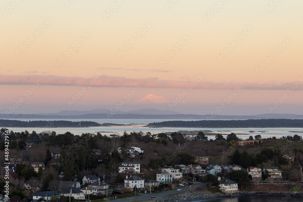 High angle view of the Oak Bay area and Washington State’s Mount Baker in soft focus background during a winter sunset from the Walbran Park Lookout, Victoria, British Columbia, Canada