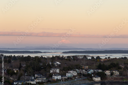 High angle view of the Oak Bay area and Washington State’s Mount Baker in soft focus background during a winter sunset from the Walbran Park Lookout, Victoria, British Columbia, Canada photo