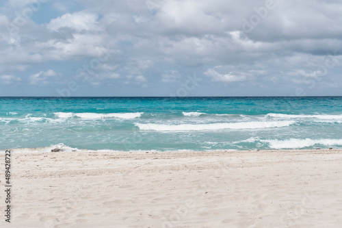 Atlantic sandy beach of Cuba  resort Varadero. Waves and cloudy sky. Scenic seascape