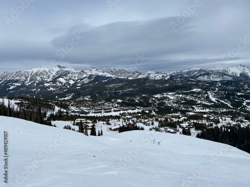 Moody view of the mountains and slopes of Big Sky Ski Resort on a cloudy winter day © Jen