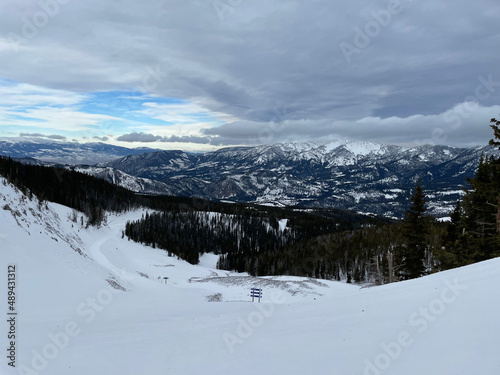Scenic view of snow covered slopes at a ski resort in Montana on a cloudy winter day © Jen