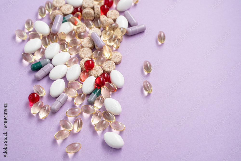 Vitamins and tablets in bulk on a pink background Vitamins and tablets in bulk on a pink background