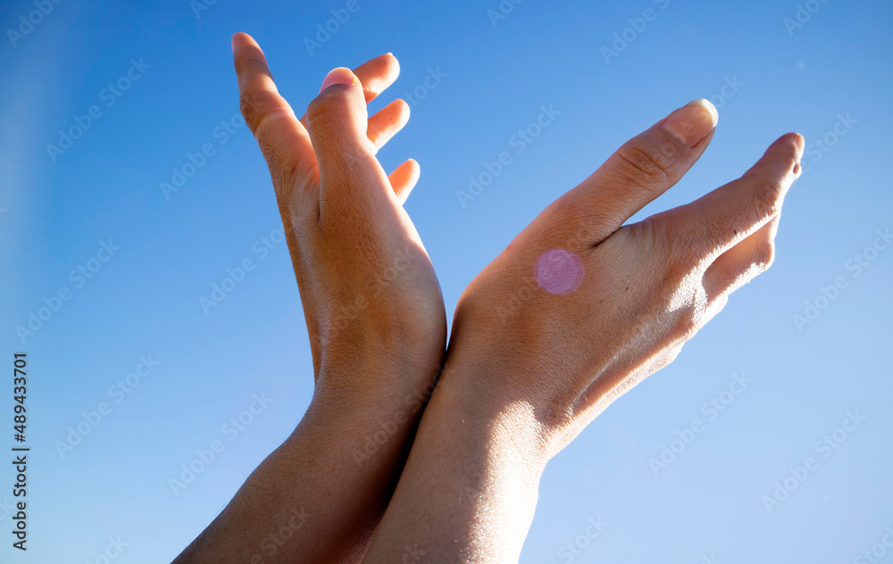 Female hands in the blue sky in the backlight Female hands in the blue sky in the backlight
