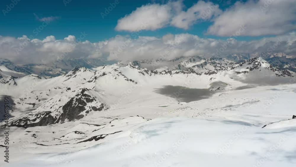 Air flight through mountain clouds over beautiful snow-capped peaks of mountains and glaciers. Air flight through mountain clouds over beautiful snow-capped peaks of mountains and glaciers.