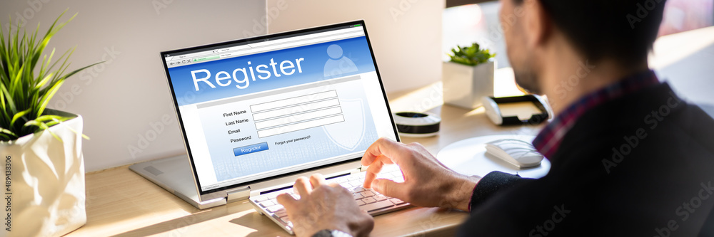 Businessman's Hand Filing Online Registration Form Businessman's Hand Filing Online Registration Form
