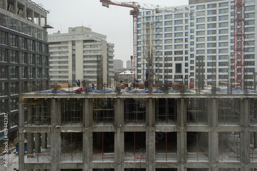 Construction site of a multi-storey building. Winter time. Several workers work on the construction site