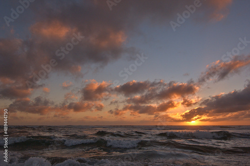 playa con olas tranquilas en medio del ocaso o puesta de sol