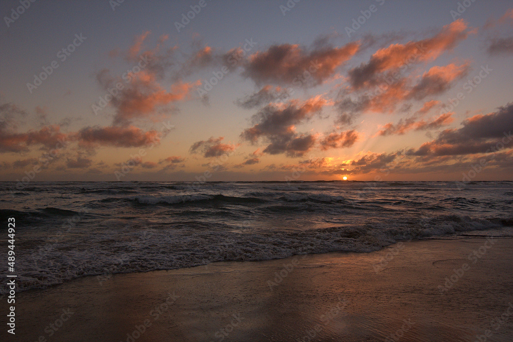playa con olas tranquilas en medio del ocaso o puesta de sol