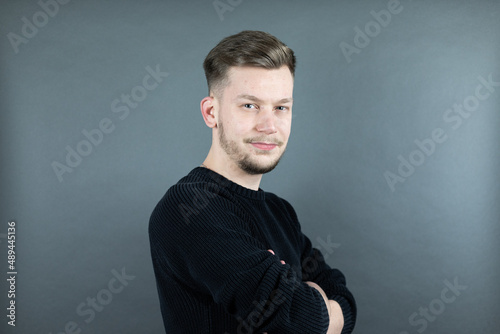 Portrait von einem jungen freundlichen Mann auf grauem Hintergrund selbstbewusst