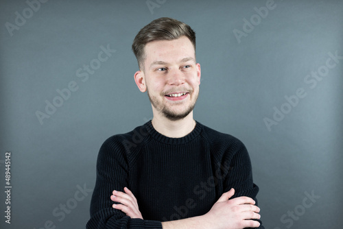 Portrait von einem jungen freundlichen Mann auf grauem Hintergrund