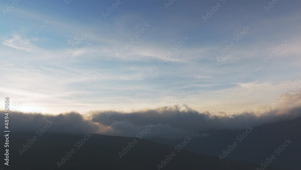 Sun shining brightly above white fluffy clouds at sunrise Sun shining brightly above white fluffy clouds at sunrise