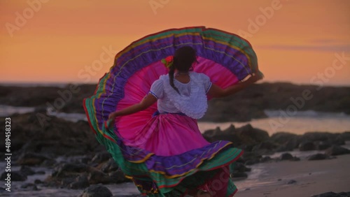 Costa Rican woman in traditional Guanacaste dress dancing in sunset light filmed in slow motion