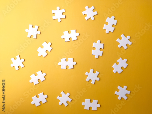 Top view blank white puzzle on a yellow background.