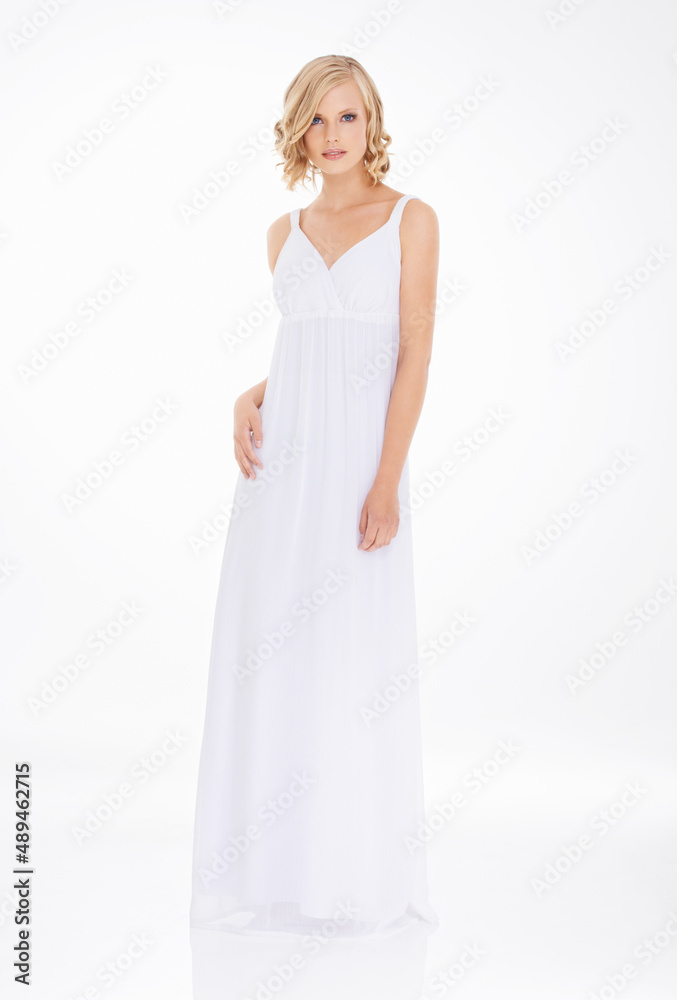 Pure elegance. Studio shot an attractive young woman in white dress.