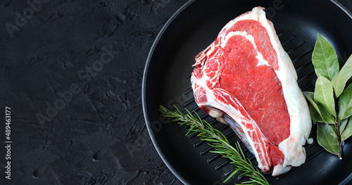 raw steak entrecote in a pan, grill, top view, copy space, dark background