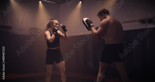 A Strong Man And Woman Sparring / Training In A Martial Arts Gym. Shot In A Crossfit Boxing Gym With Low Key Lighting And A Scattering Of Haze. Captured On Red Digital Cinema Camera 