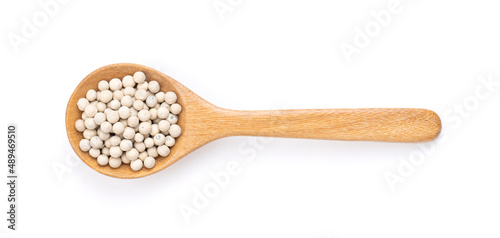 Peppercorn in wood spoon isolated on white