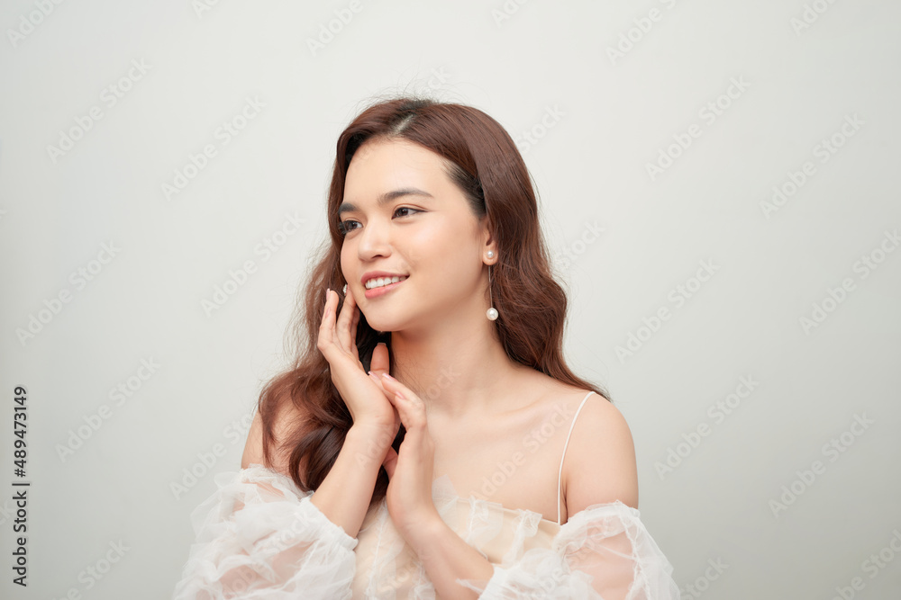Beautiful portrait of asian young woman in white blouse on grey background. Beautiful portrait of asian young woman in white blouse on grey background.