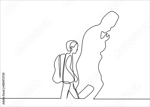 a little student walks daydreaming and thinking and the silhouette of a commander is reflected on the wall
