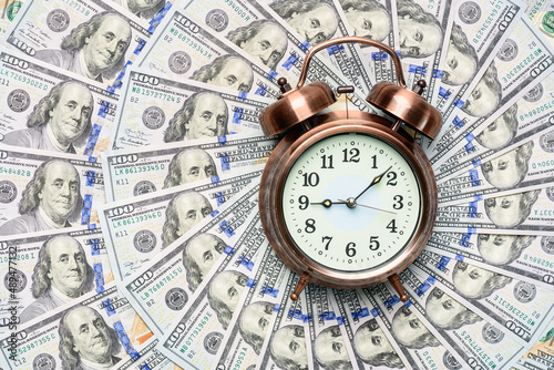 Time value of money concept : Old analog clock on US dollar banknote, depicting receiving money today can be poised to increase the future value by investing and gaining interest over a period of time photo