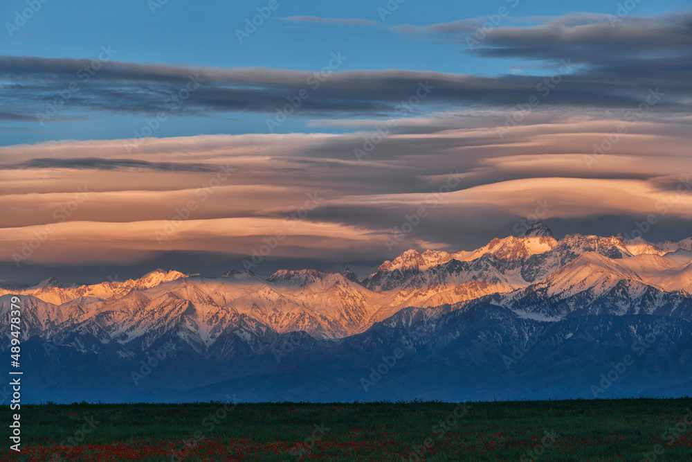 Beautiful lenticular clouds over the peaks of the mountains of the Trans-Ili Alatau