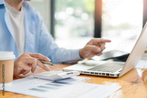 Business analyst concept the accountant using a calculator to estimate the amount of profits