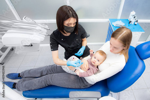mom and baby at the reception at the pediatric dentist. First visit to the dentist. Diagnosis and treatment of milk teeth in children and infants photo