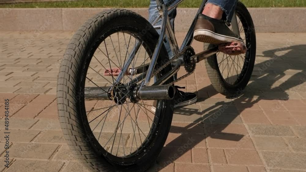 Close-up of a young guy's foot on a BMX Bicycle pedal in a Park in the summer. Close-up of a young guy's foot on a BMX Bicycle pedal in a Park in the summer.