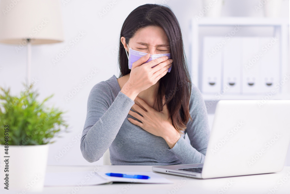 Stressed young woman wearing medical face mask and working at home office Stressed young woman wearing medical face mask and working at home office