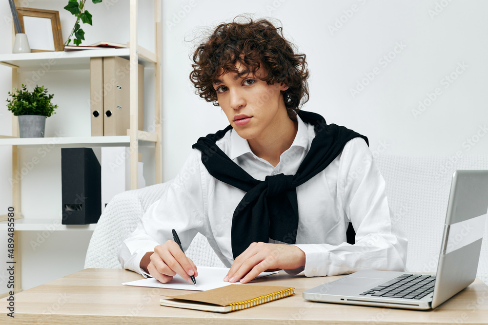 curly guy on a white sofa in front of a laptop learning Lifestyle technology curly guy on a white sofa in front of a laptop learning Lifestyle technology
