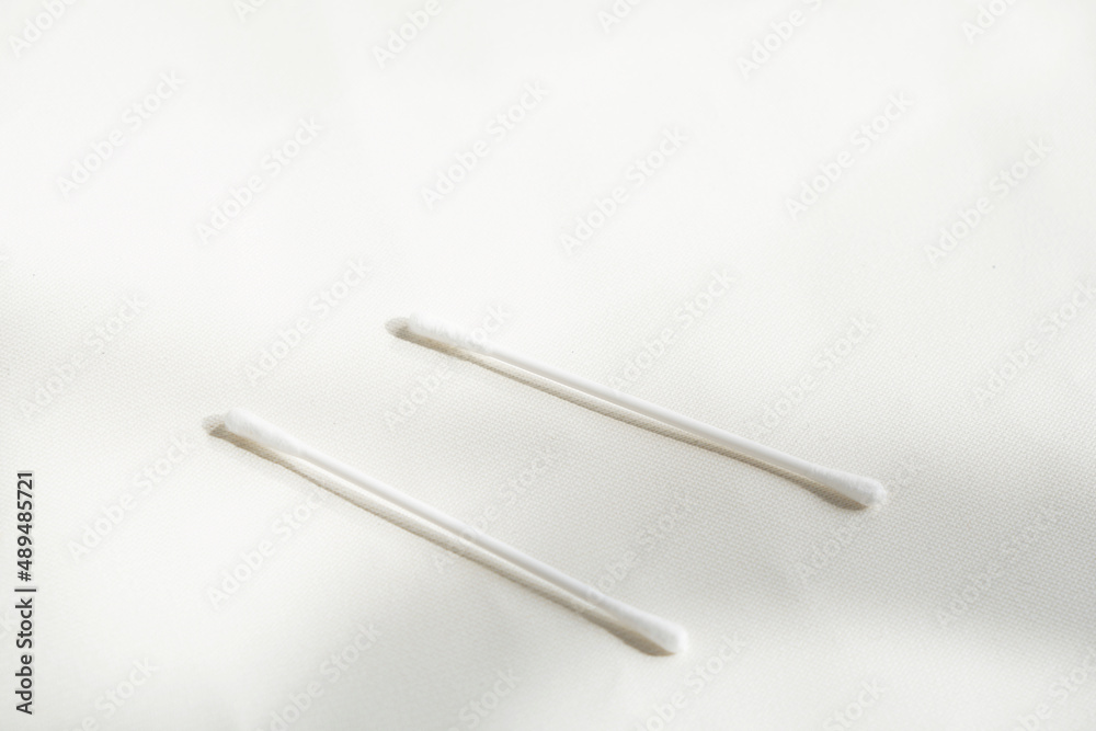Two cotton bud on white background in shadow and light in the window light. Two cotton bud on white background in shadow and light in the window light.