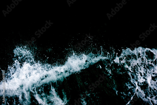 Top view of the ocean waves. Abstract blue ocean water with white foam background. Sea waves texture. Selective focus.