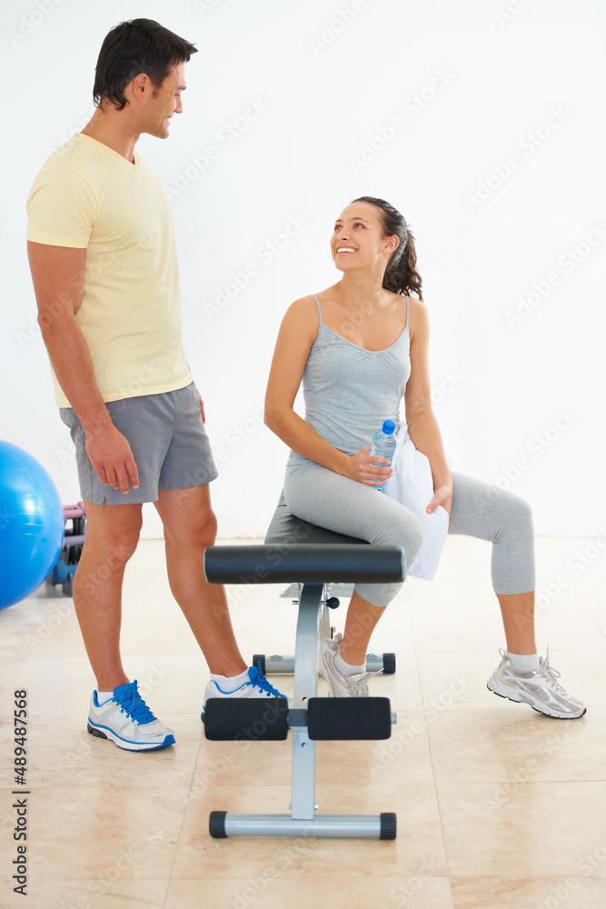 Obraz premium Ready to exercise. Two young people talking to each other at the gym.