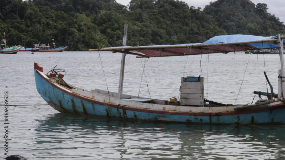 Old Wooden Fishing Boat With Nature Background. the boat is tossed by