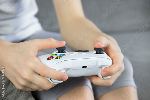 computer game competition. Game concept. An excited girl is playing a video game with a joystick. The girl's hands are holding a white gamepad