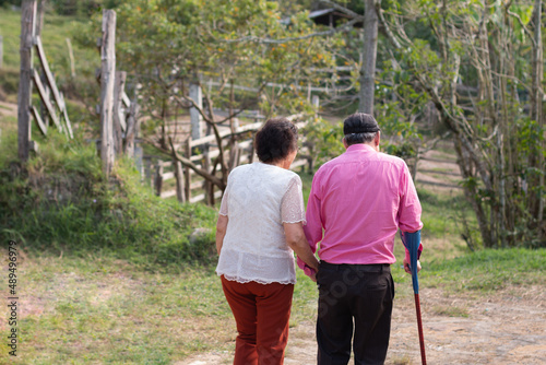Elderly couple walking hand in hand. Two elderly people taking a walk through nature.