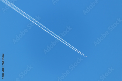Condensation trail of a flying jet plane in the blue sky
