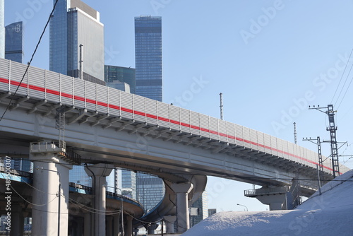 Overpasses on the background of skyscrapers. Blue sky and bright sun. Transport interchanges and urbanism. photo