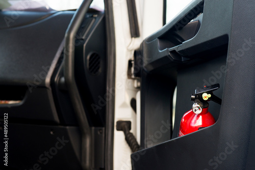 Foto Red fire extinguisher in a black truck door.