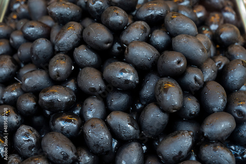 Black olives close up on market  food background