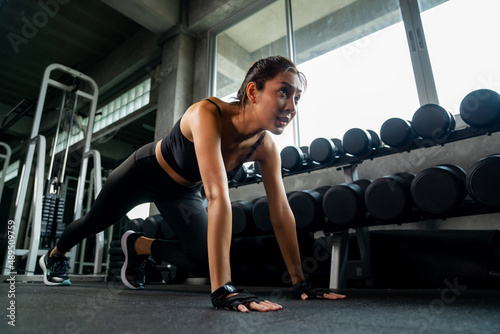 Healthy Asian athlete woman do running plank workout exercise body weight lifting at fitness gym. Strong female do body muscle building weight training at sport club. Health care motivation concept