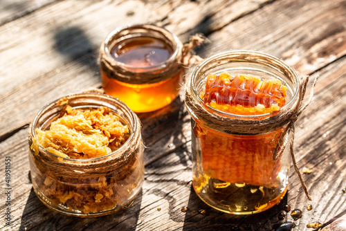 Natural honey comb and a glass jar on wooden table. Honey background. Sweet honey. Long banner format. space for text