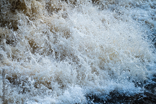 close up of flowing water, rapid water splashes of an white water river or stream, bubbly water © ako-photography
