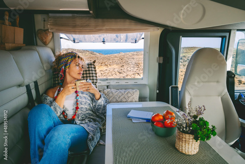 Obraz na plátně Cute trendy adult woman have relax leisure activity laying on the sofa inside her cozy alternative home camper van