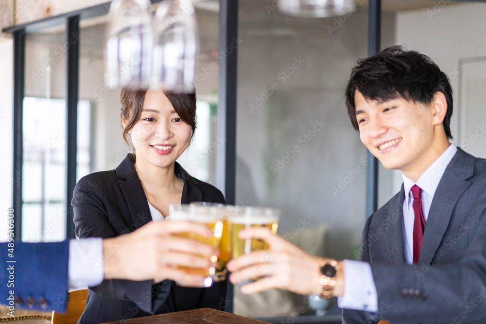 ビールで乾杯をするビジネスパーソン ビールで乾杯をするビジネスパーソン