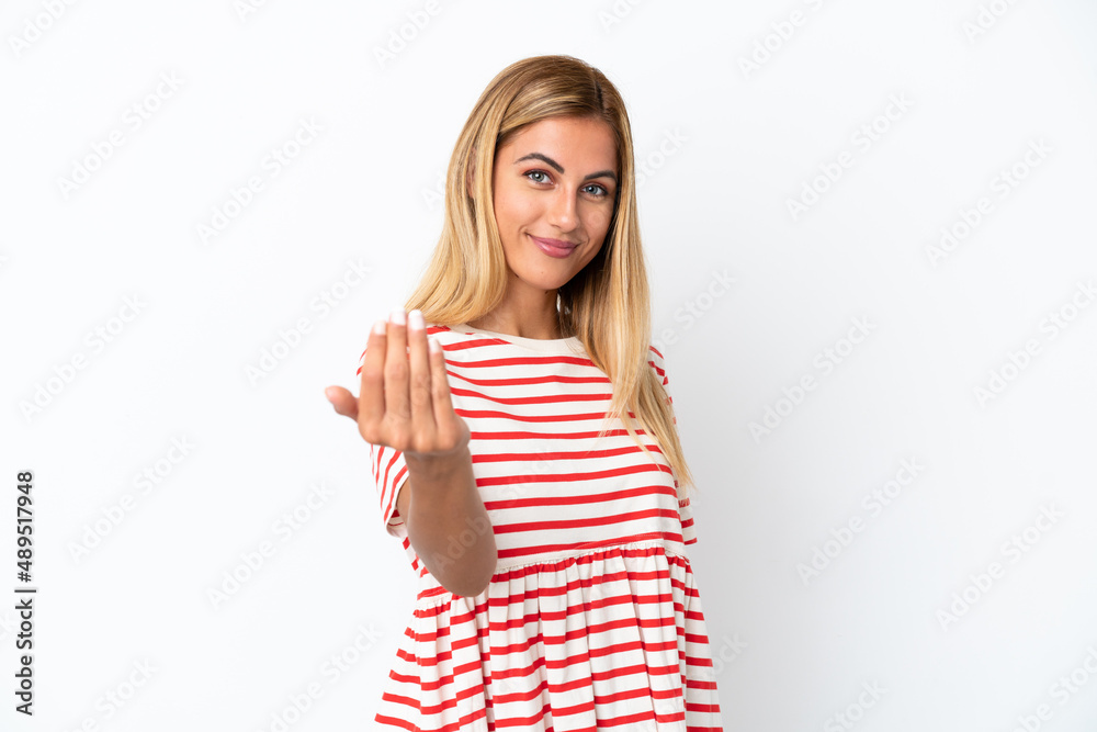 Blonde Uruguayan girl isolated on white background inviting to come with hand. Happy that you came