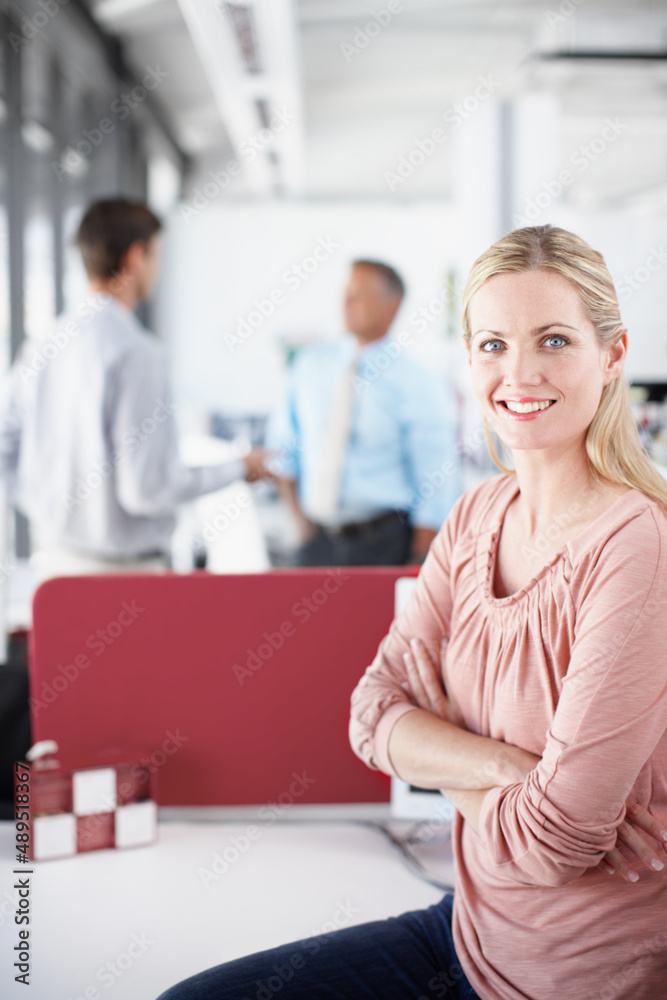 Professionalism alongside copyspace. Portrait of a young businesswoman crossing her arms as colleagues converse in the background. Professionalism alongside copyspace. Portrait of a young businesswoman crossing her arms as colleagues converse in the background.