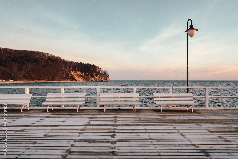 Benches on the pier with a view of the cliff and the Baltic Sea in Gdynia Orlowo. Poland - obrazy, fototapety, plakaty 